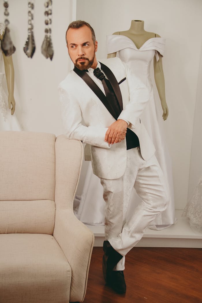 The Art of Drawing Readers In: Your attractive post title goes here A stylish man in a white suit poses indoors, exuding sophistication and charm.