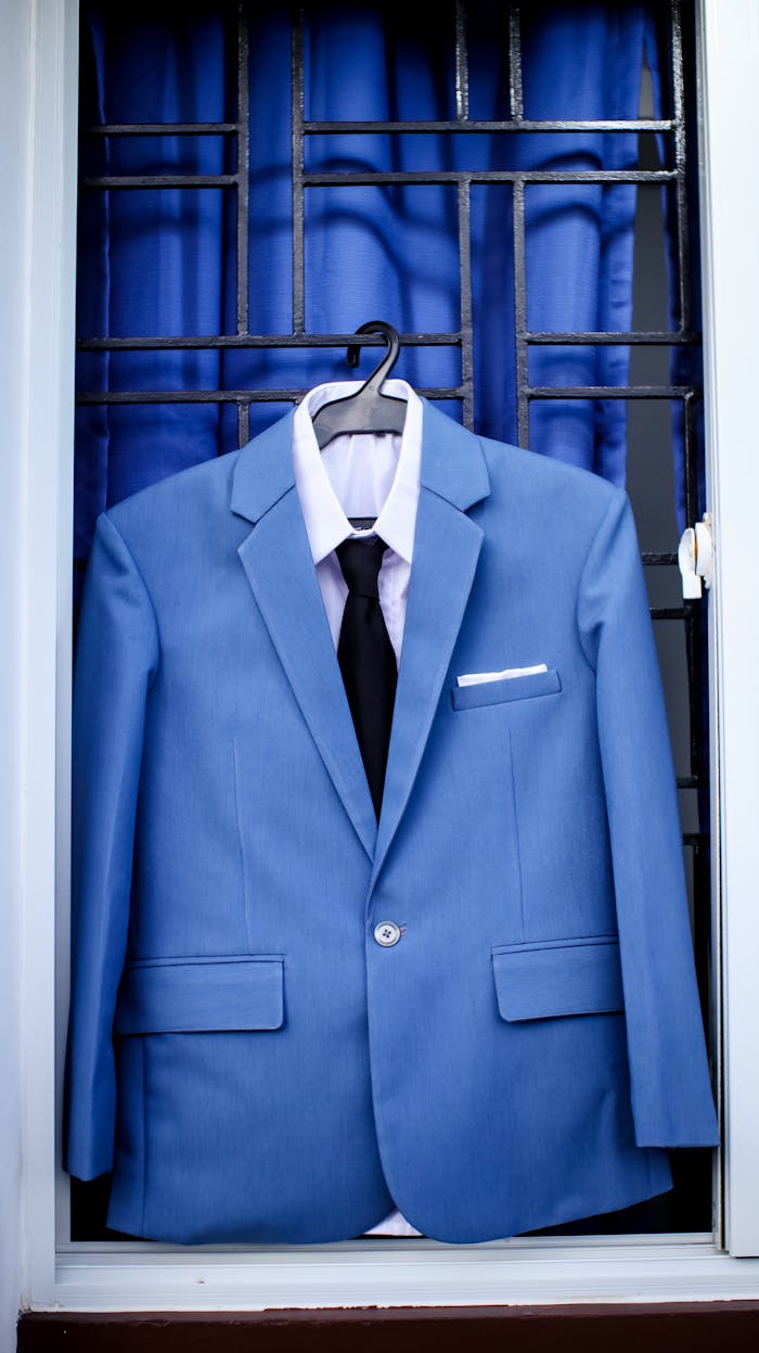 services-06 Classy light blue suit on hanger with black tie and white shirt placed on window bars